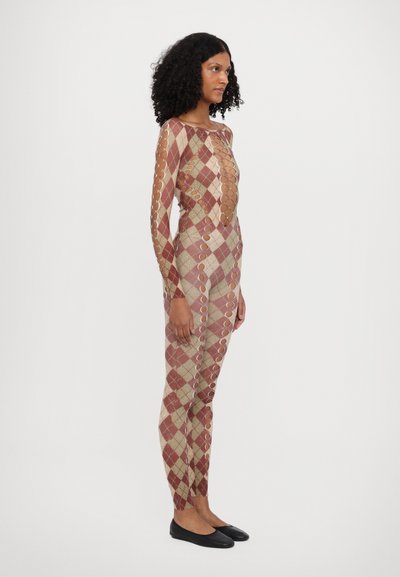Langermet jumpsuit med rutet mønster i rødt og beige, med utskårne sirkler langs ermene og sidene.