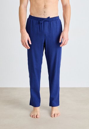 Pantalons de pyjama à carreaux bleu marine avec une taille élastique et un cordon de serrage. Tissu léger avec une coupe décontractée.