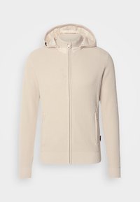 Cream ribbed hoodie with a full zip closure, kangaroo pockets, and a smooth-lined hood. Soft texture with fitted cuffs and hem.