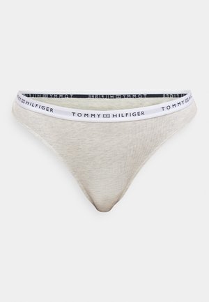 Világosszürke tanga puha anyagból, fehér elasztikus derékpánttal, amelyen a "TOMMY HILFIGER" felirat látható, valamint fekete díszítőcsíkokkal.