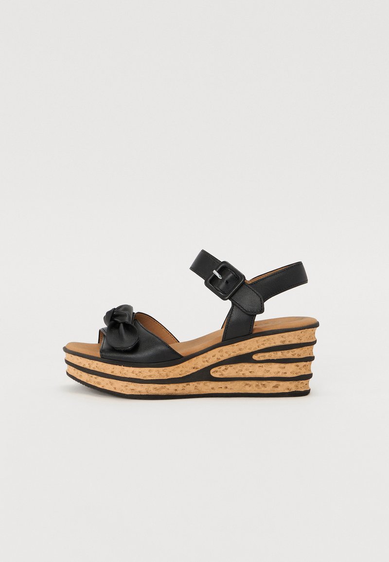 Sorte lær wedge sandaler med korksåle, med avrundet tå, ankelstropp og dekorativ sløyfe foran.