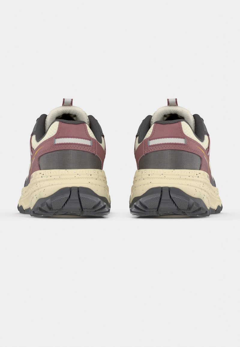 Paire de baskets épaisses beige, bordeaux et grises, vues de dos sur un fond clair uni.
