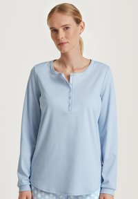 Lichtblauw langemouwen top van zachte stof, met een ronde kraag en een vijfknopenlijst, in een relaxte pasvorm met geribbelde mouwen.