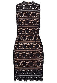 Hihaton beige mekko, jossa on musta kukkalacee päällyste, korkea kaula-aukko ja aaltoileva helma.