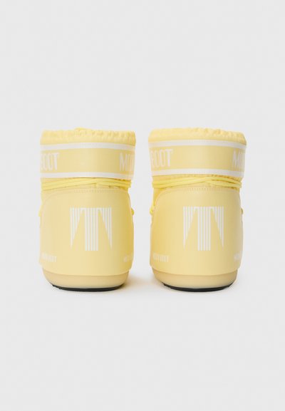 Yellow moon boots with a glossy finish, padded top, and white logo accents. Features a rubber sole and a distinctive vertical pattern on the back.