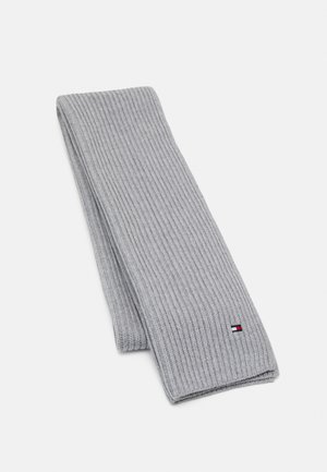 Écharpe en maille côtelée gris clair pliée avec un petit logo rectangulaire rouge, blanc et bleu près d'une extrémité sur fond blanc.