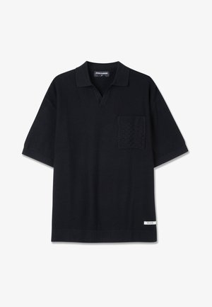 Camisa polo negra de manga corta con un bolsillo texturizado y diseño de escote en V. Elaborada en un tejido de punto texturizado con detalles acanalados en el dobladillo.