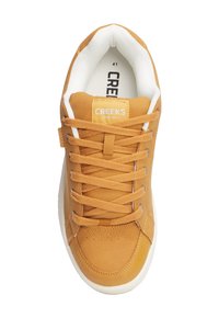 Sneaker scamosciati color tan con dettagli bianchi; presentano lacci rotondi, occhielli in metallo, perforazioni vicino alla punta e una toppa rettangolare con logo sulla linguetta.