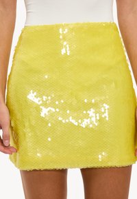 Geel met pailletten versierde mini-jurk met een aansluitend ontwerp, cirkelvormig paillettenpatroon en een soepele textuur met een rechte zoom.