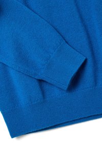 Jersey de punto azul con un acabado texturizado. Presenta puños y dobladillo acanalados, exhibiendo un tejido suave y un color rico y vibrante.