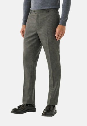 Grau- und schwarze Karohosen, tailliert mit glatter Textur. Kombiniert mit schwarzen Lederloafers.