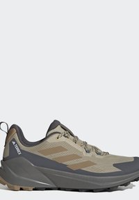 Beige og grå Adidas Terrex trail løbesko med tekstureret sål, tre striber på siden, snørelukning og polstret ankelkrave.