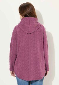 Fleece hoodie i lila med texturerad diamantmönster, långa ärmar och stor huva. Rundad fåll och avslappnad passform.