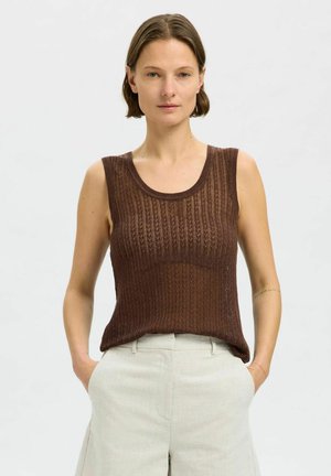 Top sans manches tricoté brun avec une texture côtelée, présentant un col rond et une coupe décontractée. Associé à un pantalon de couleur claire.