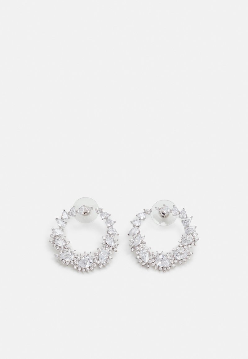 Paire de boucles d'oreilles créoles en argent ornées de pierres précieuses claires de différentes formes sur fond blanc.