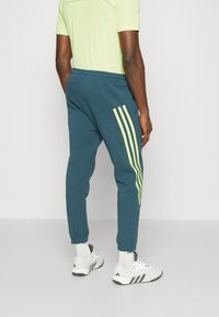 adidas Sportswear FUTURE ICONS 3-STRIPES - Pantalones deportivos - arctic night