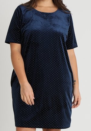 Navy blue velvety dress featuring short sleeves, a round neckline, and a polka dot pattern with small, contrasting dots throughout.