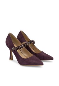 Scarpe con tacco alto in suede viola con punta appuntita e una cinghia di perline attraversante il collo del piede. Tacco quadrato in tono oro. Interno liscio.