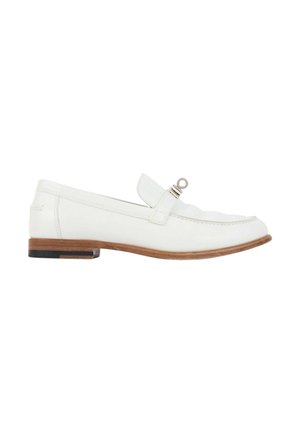Mocassin en cuir blanc avec semelle en bois et détail d'anneau argenté sur la bride, vu de profil sur fond blanc.