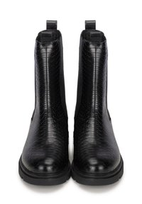 Botines negros con un patrón de piel de serpiente texturizado, suelas planas y tiradores en el eje para facilitar su colocación y retirada. Acabado en cuero suave.