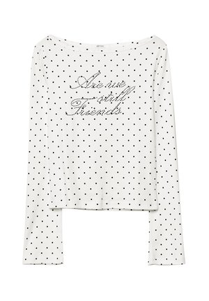 T-shirt à manches longues blanc à pois noirs, avec "As we will Friends" en strass sur la poitrine. Tissu doux, coupe décontractée.