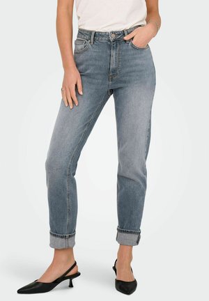 Jeans de culoare albastru deschis, cu talie înaltă, cu picior drept și margini răsucite. Fabricate din denim, cu un design clasic cu cinci buzunare. Combinate cu pantofi negri cu toc deschis.