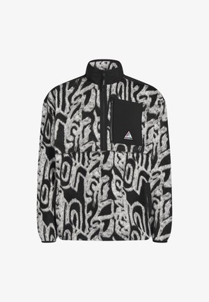 Pull en polaire noir et blanc avec motif abstrait, fermeture éclair à moitié, et poche poitrine noire avec un écusson logo.