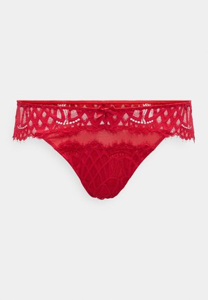 Red lace thong featuring a scalloped elastic waistband, intricate floral patterns, and a small bow accent at the front center.