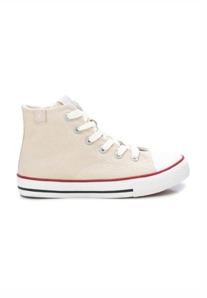 Zapatilla alta de lona beige con puntera de goma blanca, suela a rayas rojas y negras, y ojales plateados con cordones.