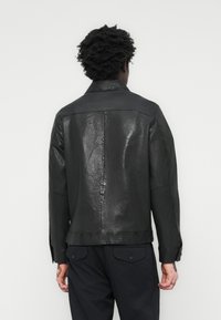 Black leather jacket with a smooth texture, featuring a classic collar, buttoned cuffs, and a straight cut design.