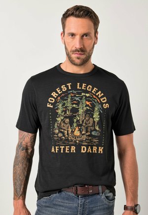Sort bomulds t-shirt med et farverigt grafik af bjørne og et lejrbål, med teksten "Forest Legends After Dark" trykt ovenfor og nedenfor.