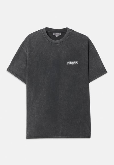 Pilkas medvilnės marškinėliai su laisvu kirpimu, apvaliu kaklu ir trumpomis rankovėmis. Yra mažas baltas logotipas kairėje krūtinės pusėje. Nusidėvėjęs audinys.