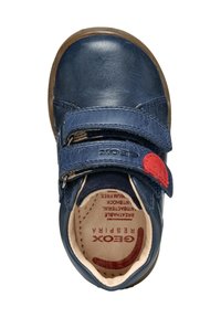 Zapato de cuero azul marino con una correa de Velcro roja, punta redondeada y suela de goma, con un interior acolchado y logo impreso en el interior.
