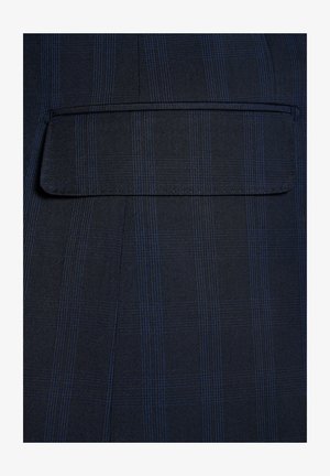 Granatowa tkanina o subtelnej kratce, zawierająca jedną kieszeń z klapką, teksturowaną powierzchnię oraz ściśle tkane włókna.