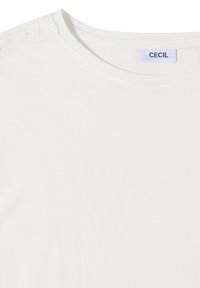 T-shirt blanc à col rond avec un détail en dentelle sur l'épaule et une petite étiquette de la marque « CECIL » à l'intérieur du col.