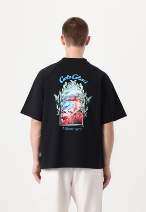 Svart bomull t-shirt med en livlig, blommig landskapsgrafik på baksidan, med texten "Carlo Colucci" och "Milano 1978" högst upp.