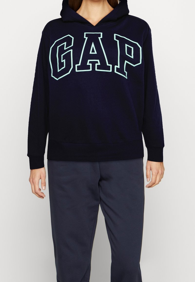 Mörkblå huvtröja i mjukt tyg med en stor ljusblå "GAP" logga fram och ribbade ärmslut och nederkant.