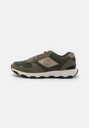 Scarpa sportiva verde e marrone caratterizzata da materiali in suede e tessuto, una suola ammortizzata, design con lacci e un dettaglio del logo ben visibile.