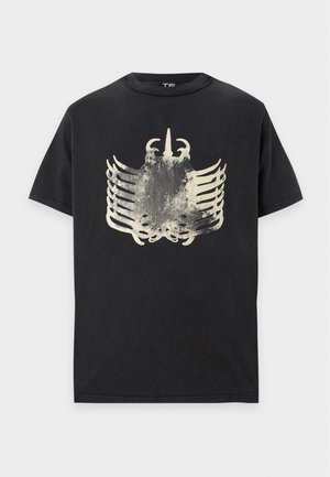 Μαύρο κοντομάνικο T-shirt με ξεθωριασμένο, αφηρημένο λευκό γραφικό που μοιάζει με θώρακα ή σκελετικό σχέδιο στο μπροστινό μέρος.