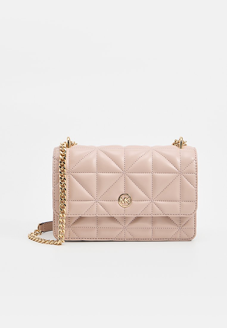 Sac à main en cuir matelassé beige avec une bandoulière en chaîne dorée et un logo rond doré MK centré sur le rabat avant.