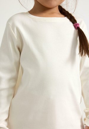 Langærmet, ribbet top i off-white, med en rund halsudskæring og en blød tekstur, samt et hårbånd i fletning bundet med en pink hårelastik.