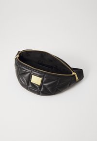 Juodas siuvinėtas odinis fanny pack'as su auksinio tono užtrauktuku ir aparatinėmis dalimis, turi kvadratinį metalinį akcentą priekyje ir glotnų vidų.