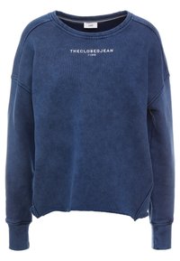 Felpa blu con collo a giro, cuciture visibili e orli strappati. Presenta un testo bianco che recita "THECLOSEDJEAN 11342" sulla parte anteriore.