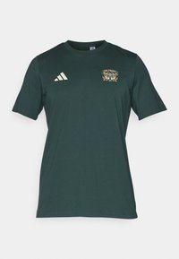 Ciemnozielona koszulka z bawełny, z krótkimi rękawami, okrągłym dekoltem i złotym wzorem graficznym z napisem "Ein Prosit." Biały logo Adidas.