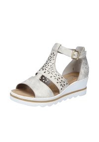 Wedge sandal in metallic silver faux leather with cut-out floral pattern, adjustable ankle strap, and white textured outsole.