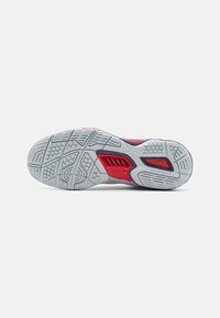 Shoe sole featuring a textured rubber exterior, predominantly white with red accents, and a patterned tread for enhanced grip.