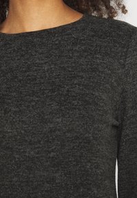 Dunkelgrauer Pullover aus einem weichen, strukturierten Stoff. Er hat einen runden Ausschnitt und enganliegende Ärmel, die ein dezentes Strickmuster zeigen.