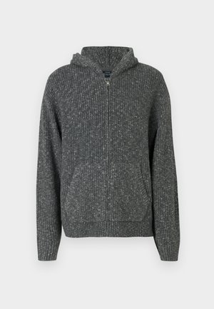 Szürke kötött kapucnis pulóver, elöl cipzárral, bordás textúrával, két elülső zsebbel és kapucnival. Jellemzője a laza, kényelmes fazon, látható varrásokkal.