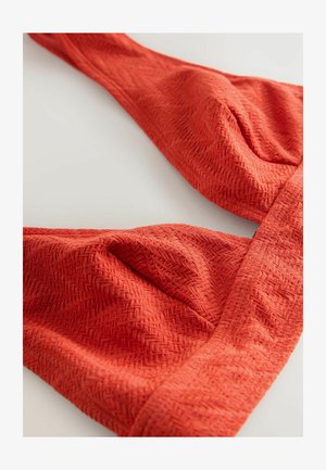 Raudonas bikini viršus su unikaliu žuvies kaulo raštu ir surinktais audinio detalėmis ant kaušelių ir dirželių.