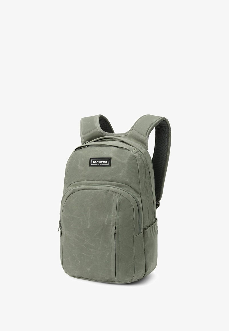 Zaino in tessuto verde con un compartimento principale e una tasca frontale con zip. Spallacci imbottiti e superficie testurizzata, con un'etichetta logo.